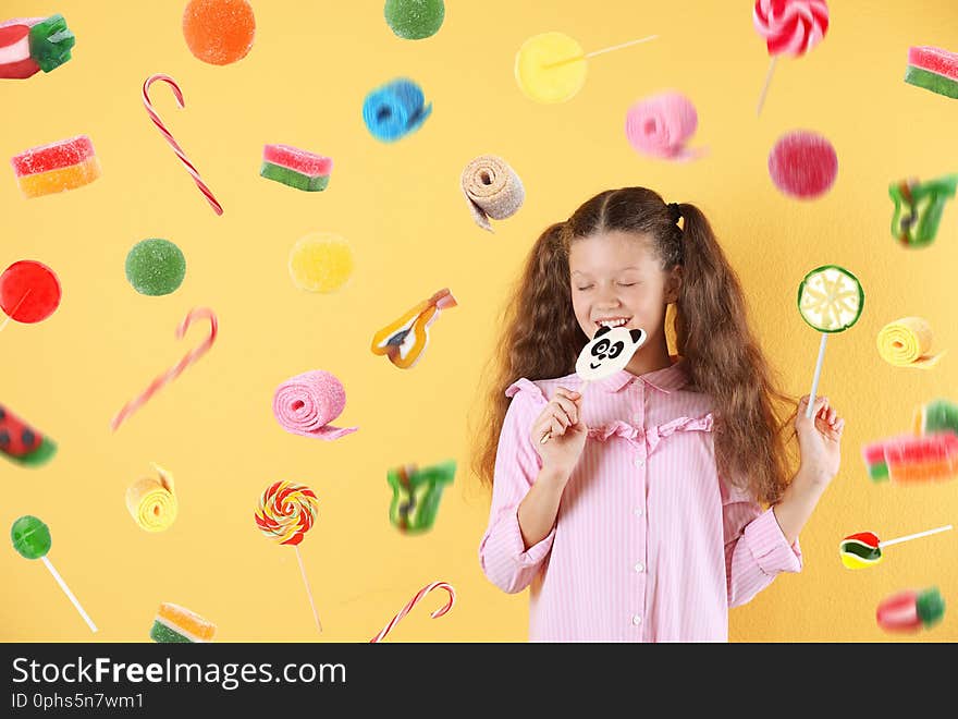 Little girl with candy on color background. Space for text