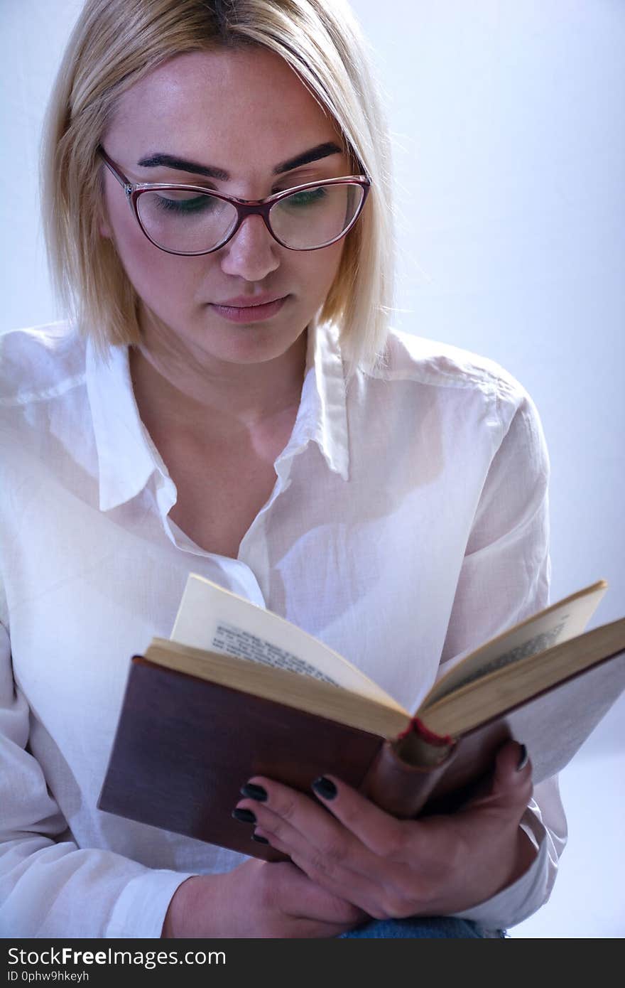 Student girl reading old book with glasses