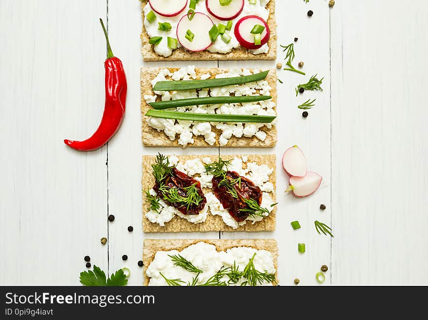 Cheese appetizers with vegetables on a white wooden background. View from above. Healthy eating