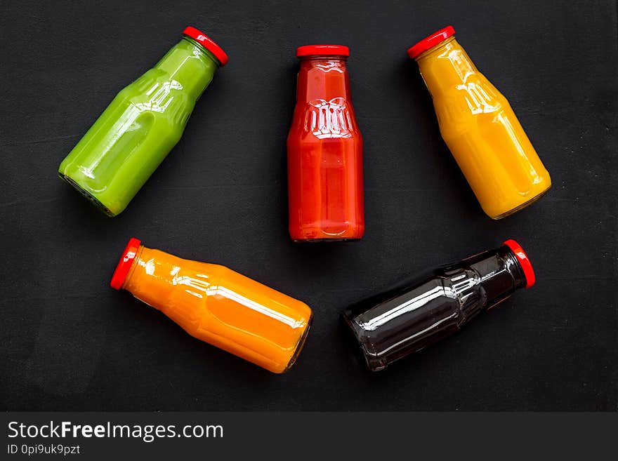 Fresh organic juices in bottles for fitness diet on black background top view mock-up