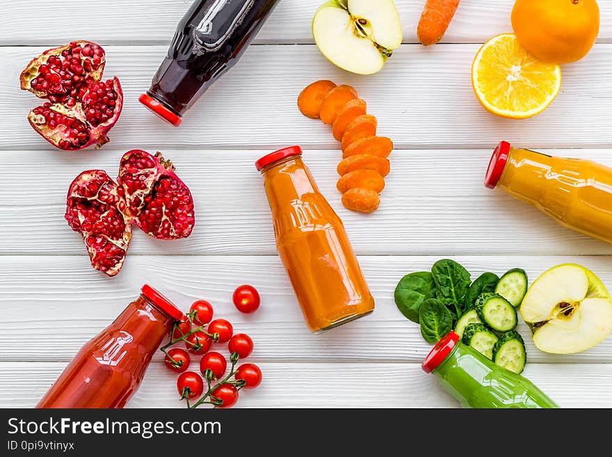 Bottles with fresh carrot, tomato, apple, cucumber, lemon, pomegranate juices for detox and diet break on white background top view copyspace. Bottles with fresh carrot, tomato, apple, cucumber, lemon, pomegranate juices for detox and diet break on white background top view copyspace