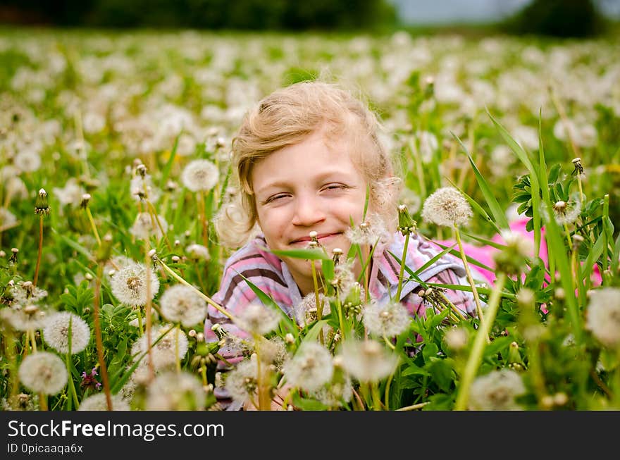 Adorable blond girl having fun in spring dandelion field. Adorable blond girl having fun in spring dandelion field