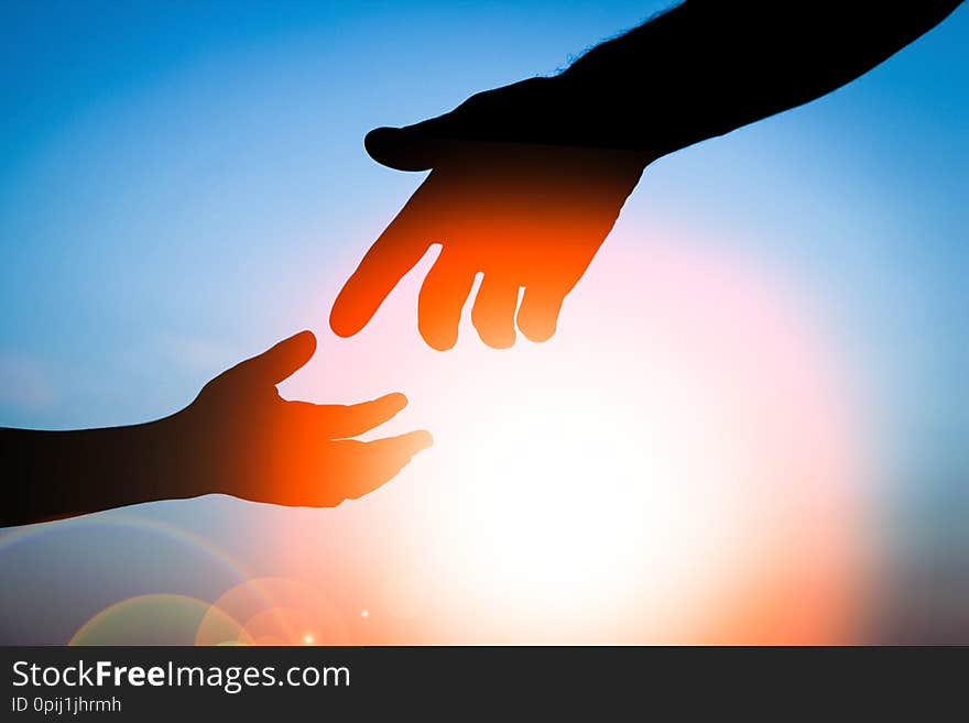 A happy parent father with baby hand silhouette at sunset in nature park