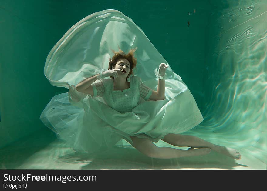 Hot Slim Woman Posing Under water in beautiful clothes alone in the deep