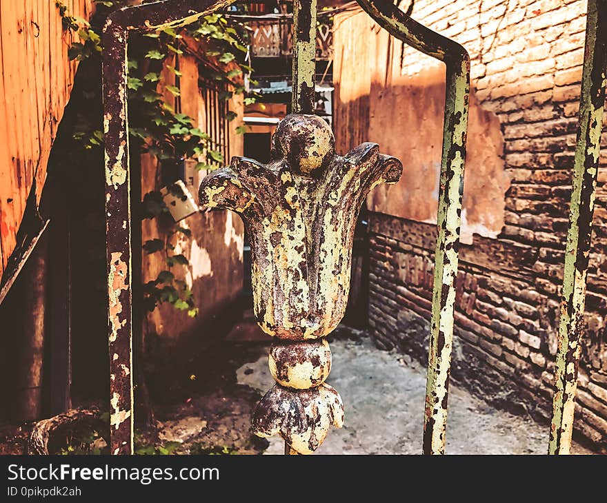 Ornament, detail of an iron gate. Old Tbilisi architecture, yard, windows in summer day. Old brick wall