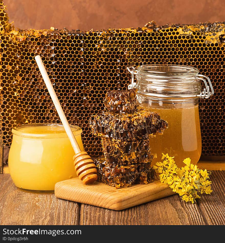 Fresh fragrant honey in a glass jar on a wooden background on the table. Different types of bee honey. Natural products.