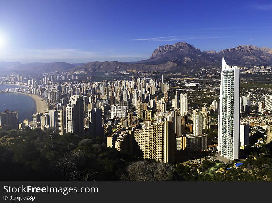 Top view of Benidorm Spain with skyscrapers and mountains and coastline on a sunny day.