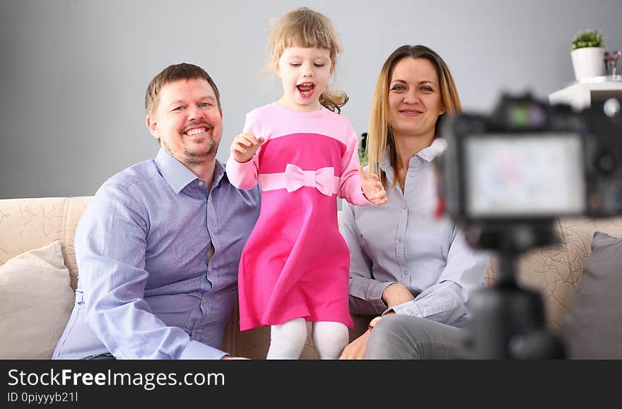 Young happy family sit on couch making photo session portrait looking at camera