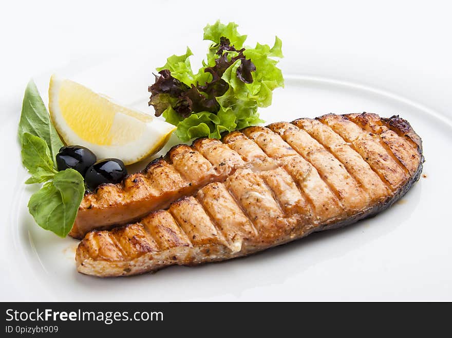 Salmon steak with lemon on white background