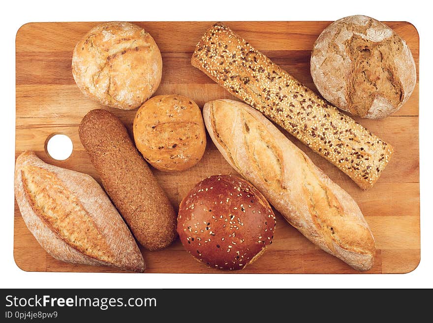 Top view of different types of bread on wooden kitchen cutting board isolated on white background