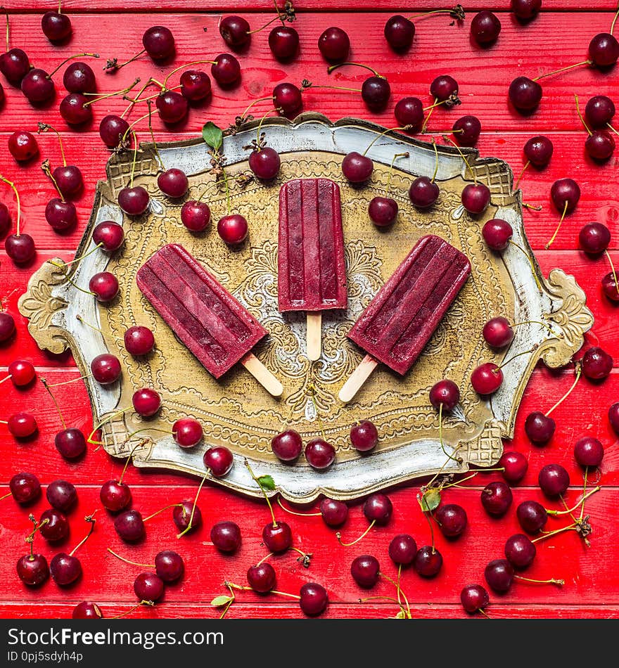 Homemade sour cherry popsicles on a vintage plate