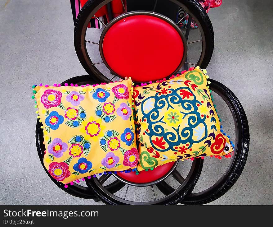 Chair made of bicycle wheels and pillows colorful - red round back.