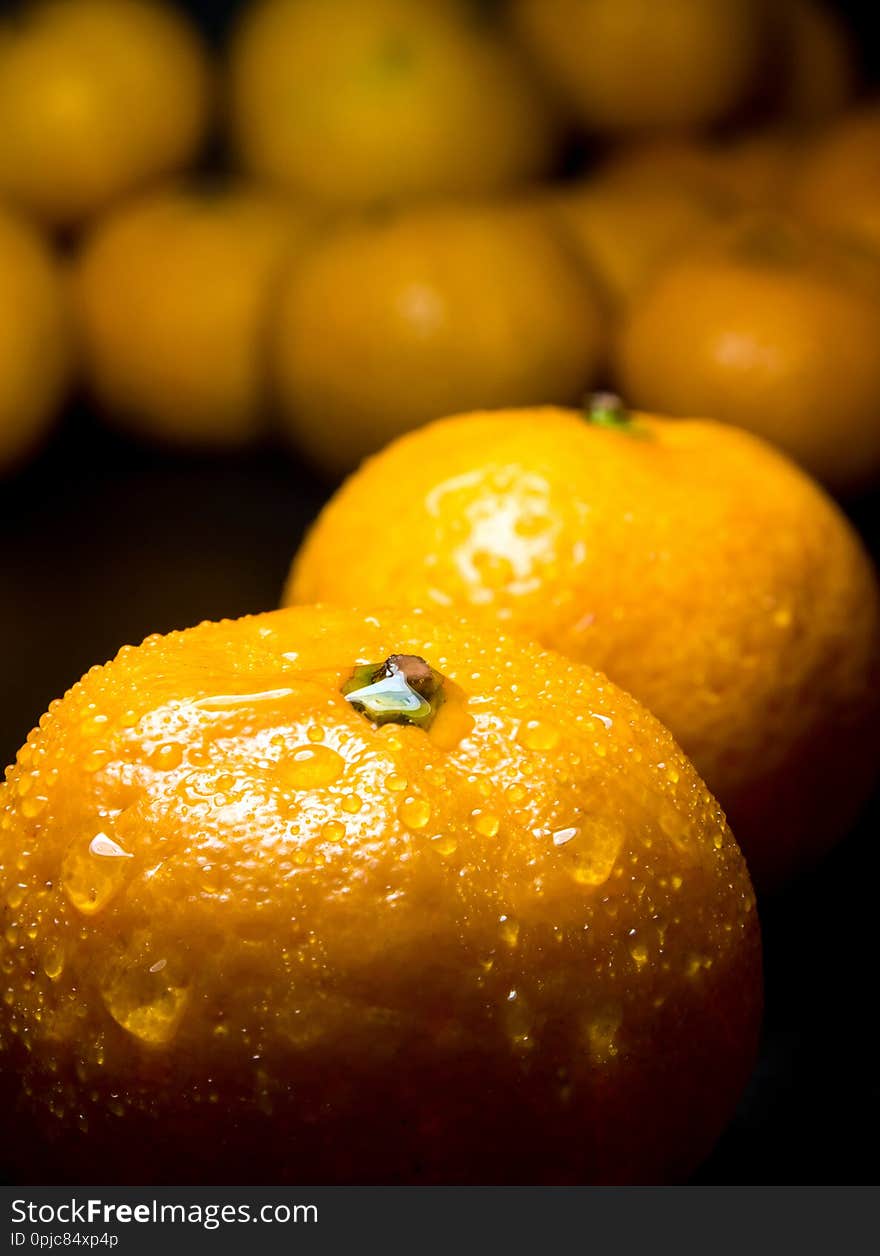 Close-up of Water droplet on glossy surface of freshness orange on black background