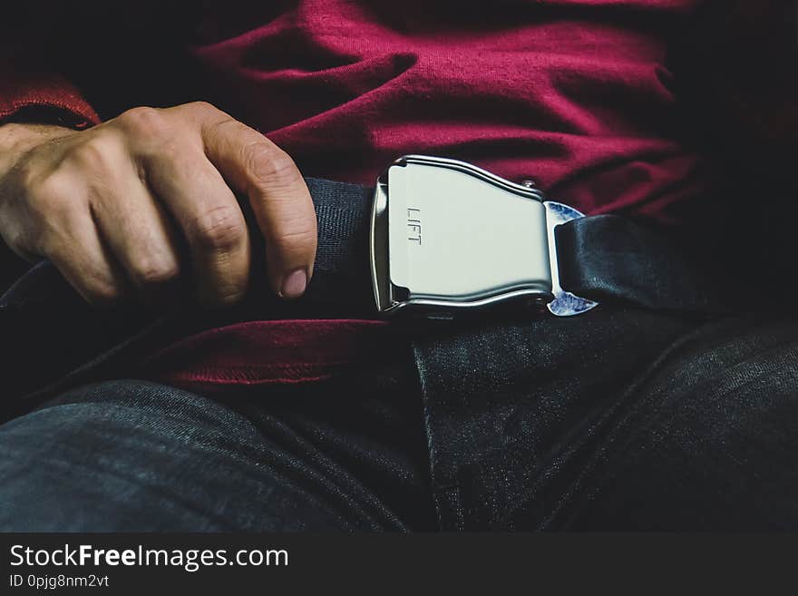 Male passenger releasing seat belt while sitting on the airplane preparing to get off. concept of a safe flight. safety while driving. turbulence during flight