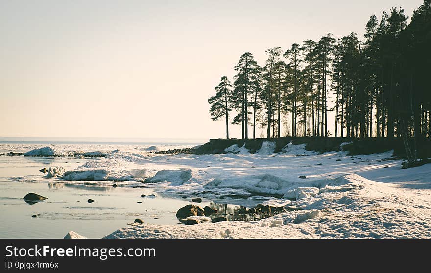 Snow pile, hill. Large snow drift isolated on a blue sky background,  outdoor view of ice blocks at frozen finland lake in winter