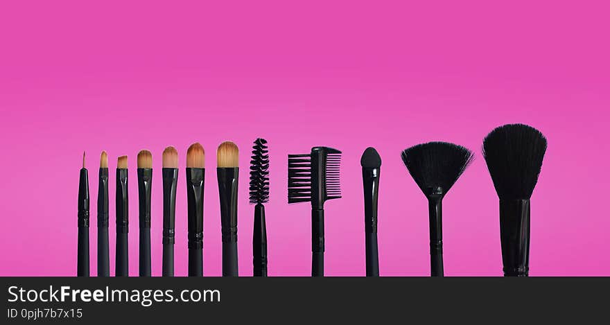 Set of makeup brushes on colored composed background