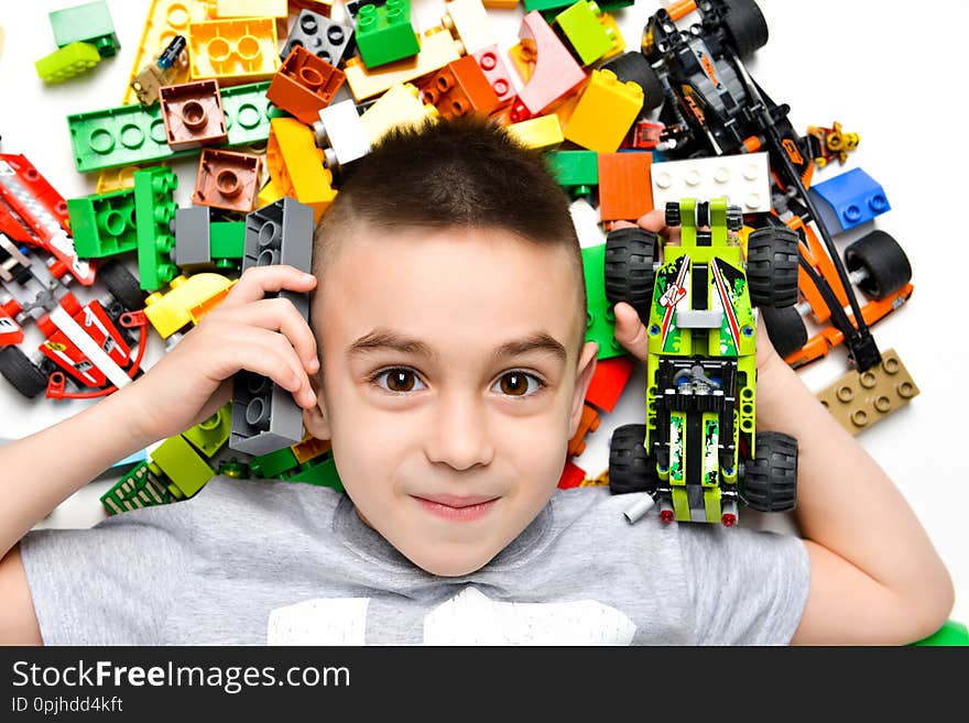 Little Child Playing With Lots Of Colorful Plastic Toys Indoor, Building Different Cars And Objects