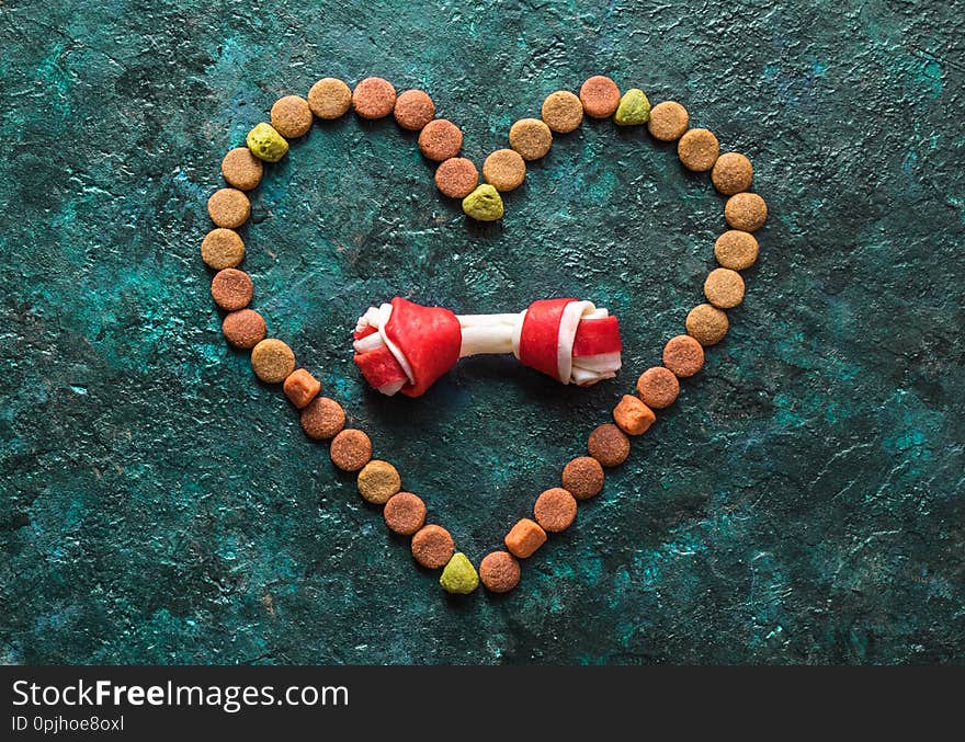 Dry dog food in heart shape on the table