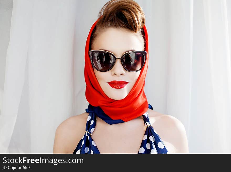 Young beautiful woman with red lipstick and a headscarf.