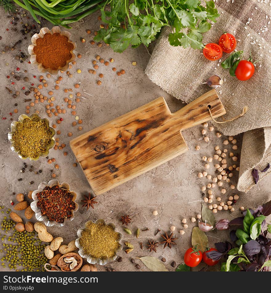 Fresh greens and tomatoes spices cereals and nuts organic healthy snacks on a textural background. Concept of healthy food. Frame under the text