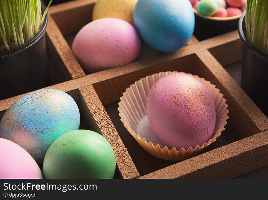 Colourful easter eggs in paper mold in wooden container. Colourful easter eggs in paper mold in wooden container