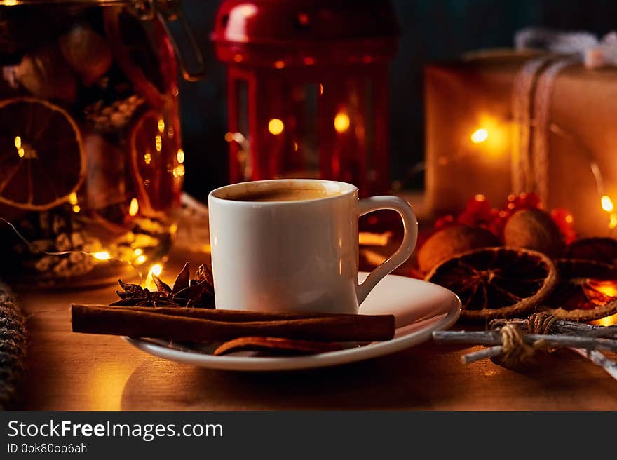 Cup of coffee in festive decorations with a fairy garland lights