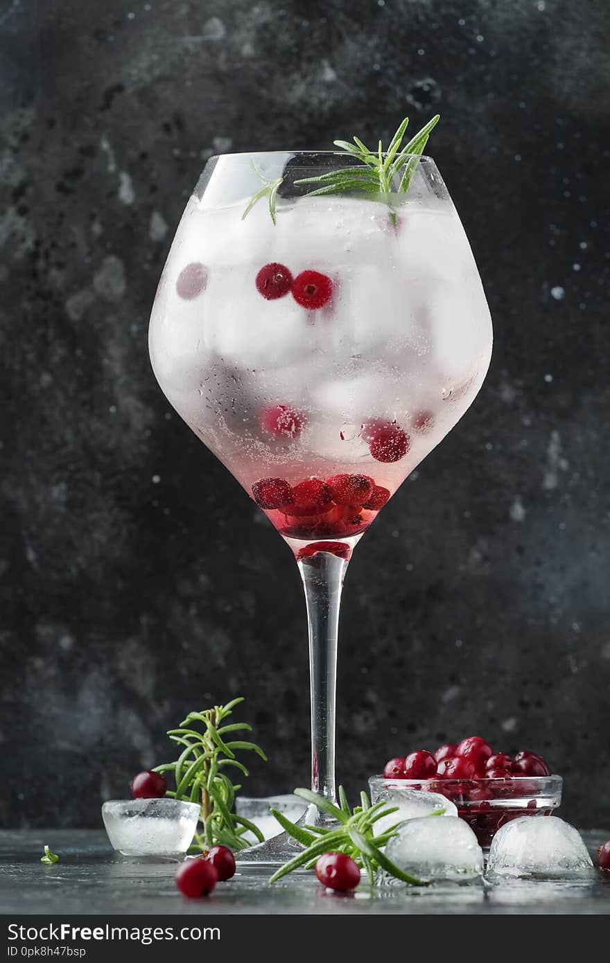 Cranberry Cocktail With Ice, Fresh Rosemary And Red Berries In Big Wine Glass, Bar Tools, Gray Bar Counter Background, Copy Space