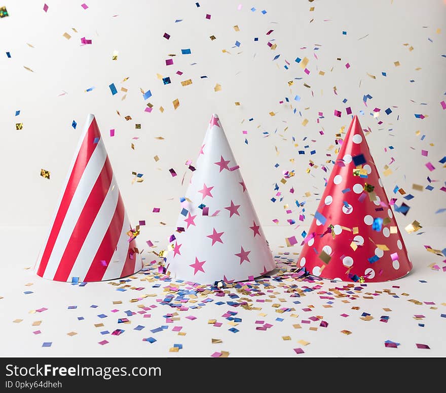 Colored confetti and party hat on white background. Minimal party concept.