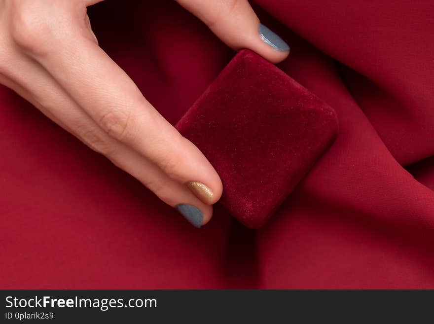 Red gift box in female hand, close up