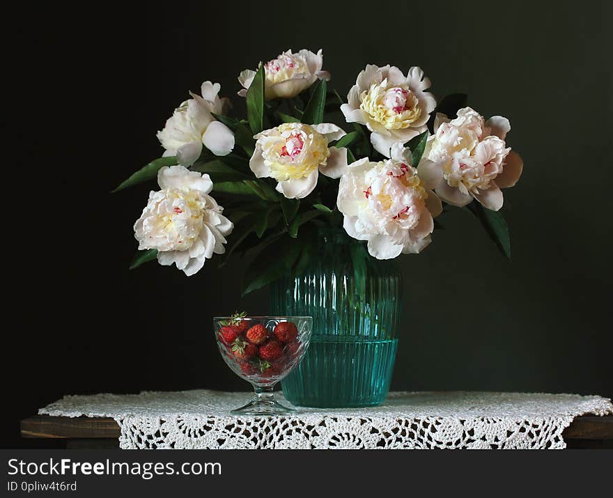 Bouquet of white peonies and strawberries on a dark background. garden flowers in a vase