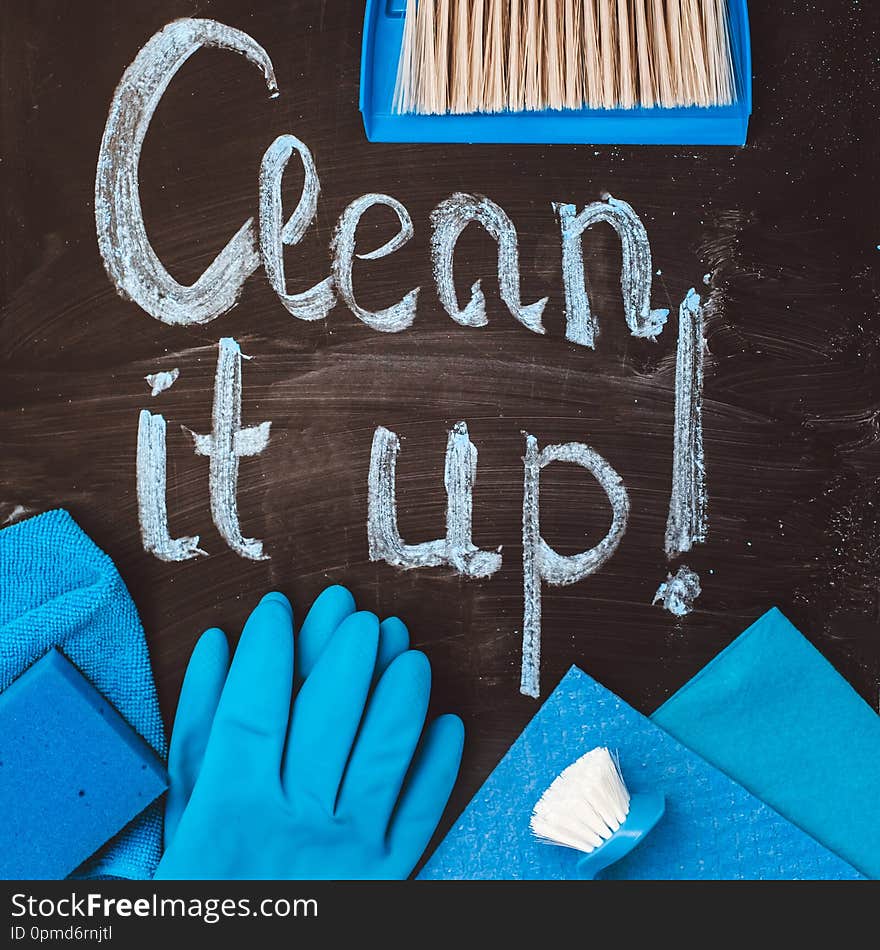 The call to ` clean it up! `written in chalk on a blackboard, surrounded by cleaning tools in the house.