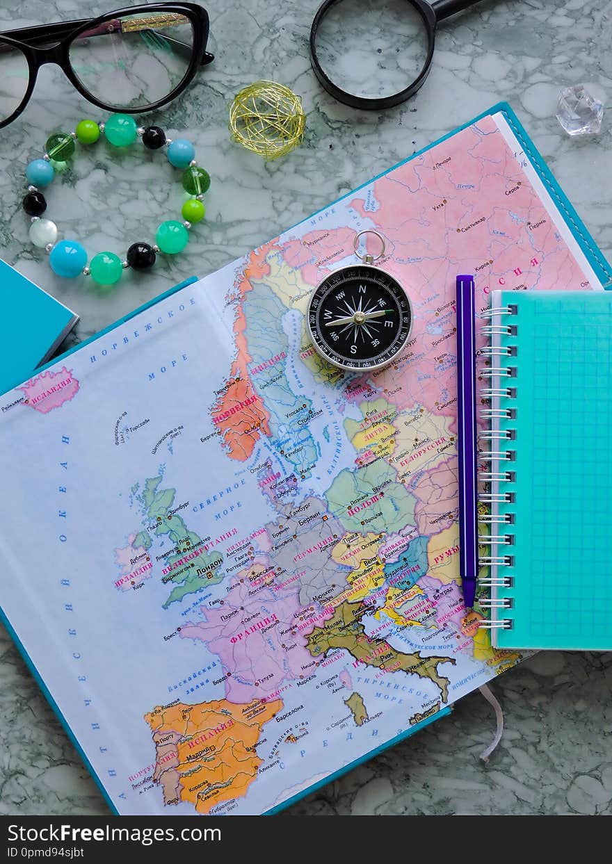 Top View of a map and items. Planning a trip or adventure. Travel planning dreams. Map of the world. Travel, tourism and vacation concept background. Stylish notebook, map and magnifier. Flat lay.