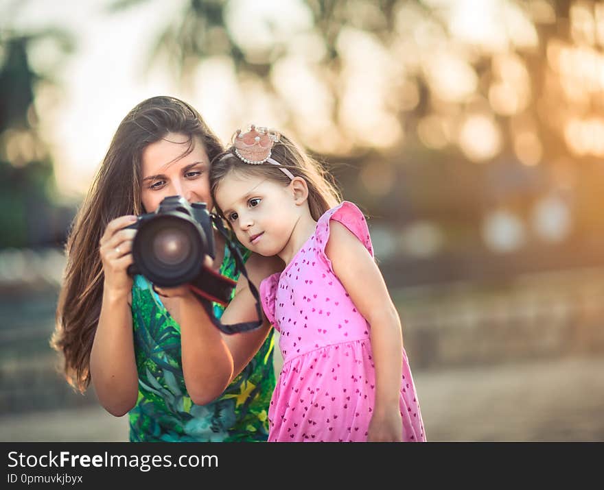 Mother and daughter taking photos with camera