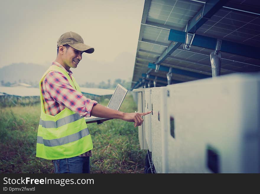 Engineer or electrician holding laptop for inspect and checking string inverter by wifi technology ;smart technology for operate