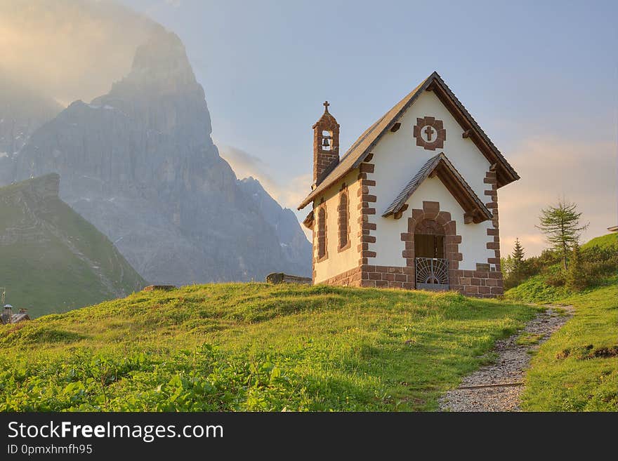 Morning scenery of a lovely church at the foothills of rugged mountain peaks  Cimon della Pala  under dramatic dawning sky in Passo Rolle, Dolomiti, Trentino Alto Adige, South Tyrol, Italy, Europe