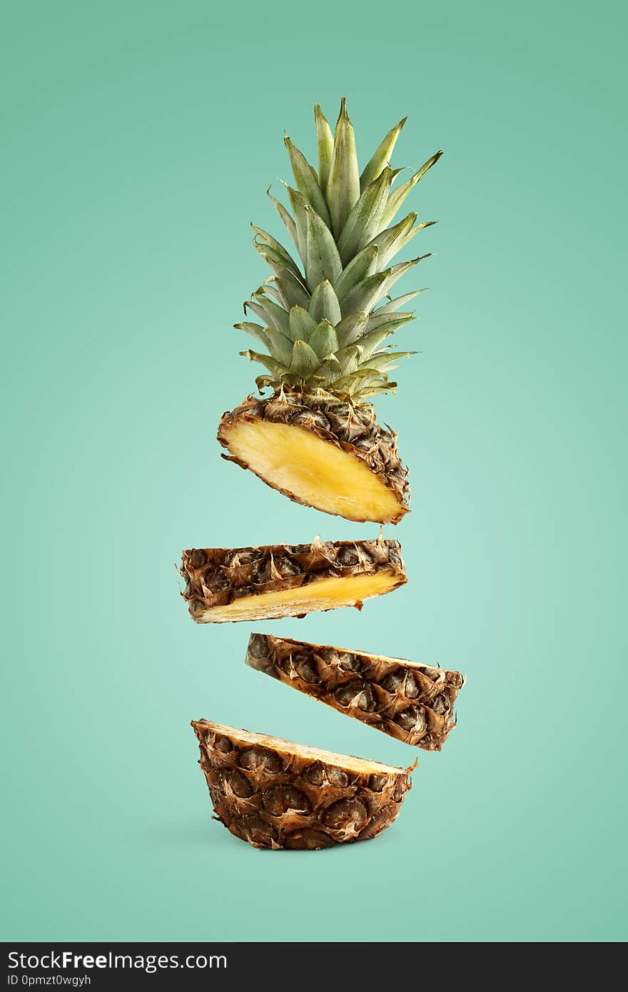 Pineapple sliced, levitates in the air. Concept of summer mood on a green background