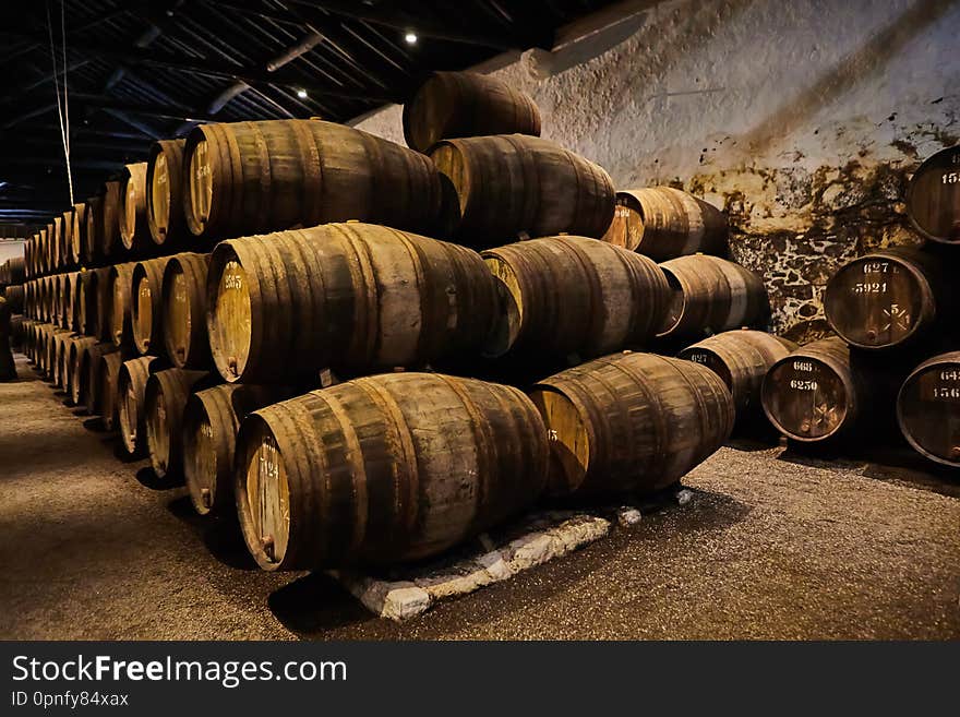 Old aged traditional wooden barrels with wine in a vault lined up in cool and dark cellar in Italy, Porto , Portugal, France