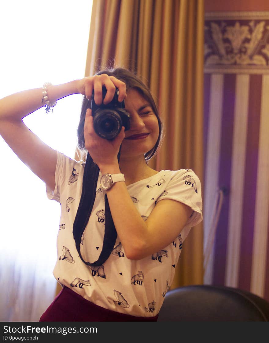 A beautiful girl takes pictures in the studio.