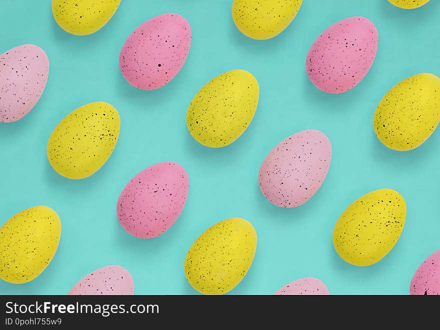 Pink and yellow Easter eggs in a repeat pattern on a bright blue-green background. Pink and yellow Easter eggs in a repeat pattern on a bright blue-green background