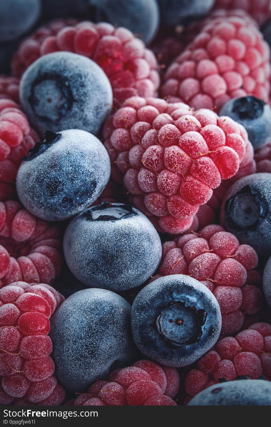 A closeup of a lot of raspberries and blueberries, fresh from the freezer with ice crystals on them. A closeup of a lot of raspberries and blueberries, fresh from the freezer with ice crystals on them