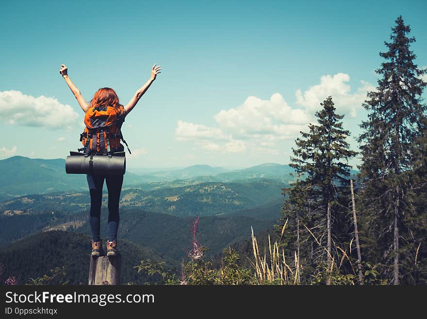 Girl hiker with a backpack standing on the background of mountains and forests. Carpathians, Ukrainian landscape. Girl hiker with a backpack standing on the background of mountains and forests. Carpathians, Ukrainian landscape