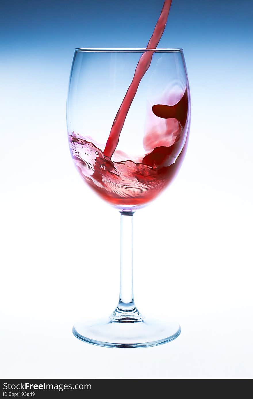 Splash red wine glass against a white background