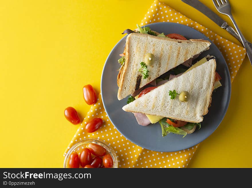 Sandwich with ham. Toasted double panini with ham, cheese fresh vegetables.Yellow background. Copy space food lettuce turkey olive bread meat lunch snack meal breakfast dinner green tomato grilled delicious rustic wooden club cuisine slice tasty gourmet healthy salad melt hot pressed cut smoked crispy heated white work triangle cherry take away colorful summer