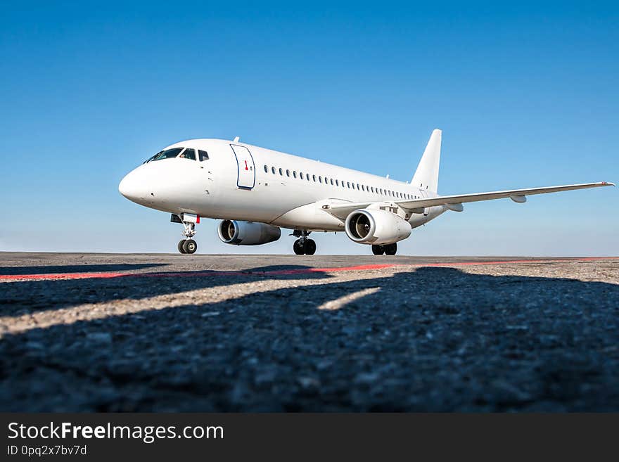 White passenger jet plane on the airport apron