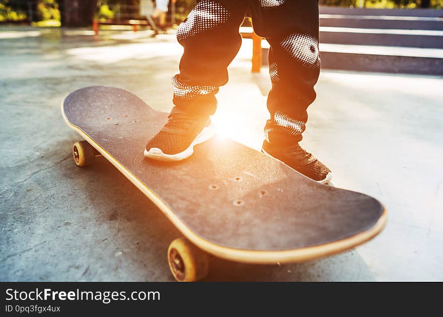 Boy legs in black shoes on the skateboard close up image. Boy legs in black shoes on the skateboard close up image