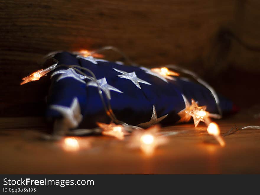 American flag with Garland on a wooden background for Memorial Day and other holidays of the United States of America.