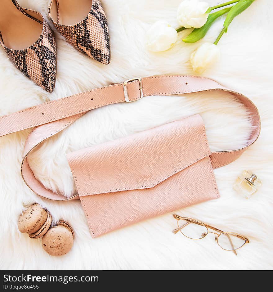 Pink leather bag on a white fur background