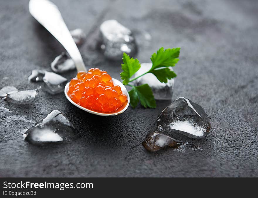 Spoon with delicious red caviar on a black background. Spoon with delicious red caviar on a black background