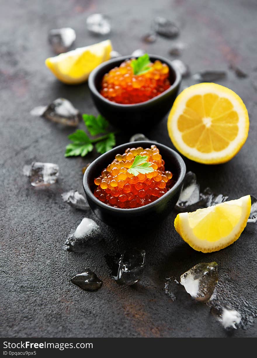 Red caviar in bowls on a old black background