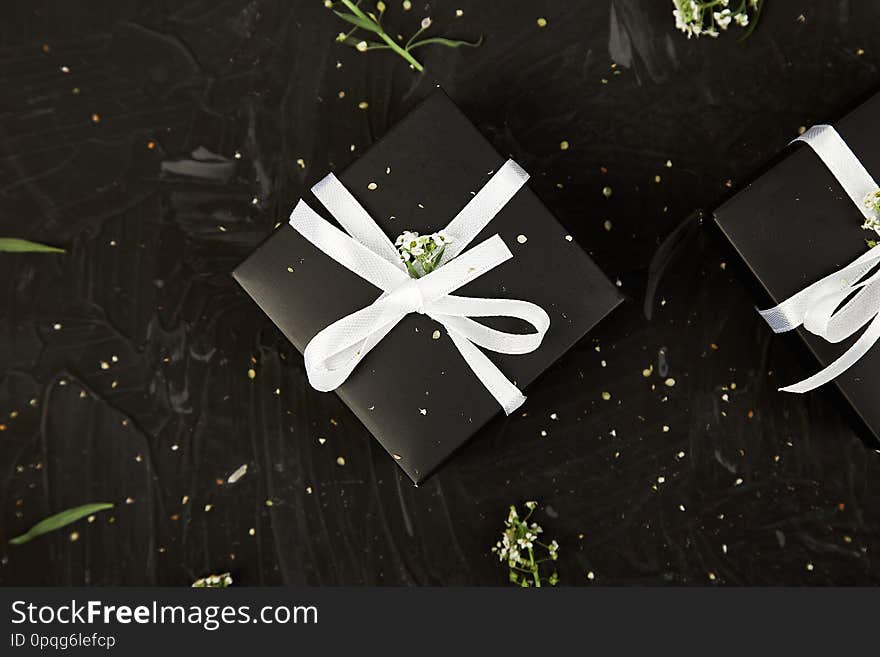 Wrapping modern Christmas or Birthday gifts presents. Gift boxes in Black and White color with flowers. Flat lay, top view. Beautiful